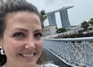 Around the World in 8 Days (And Other Things I Never Thought I’d Do) The author pictured ion a hop on, hop off bus in Singapore with Marina Bay Sands behind her