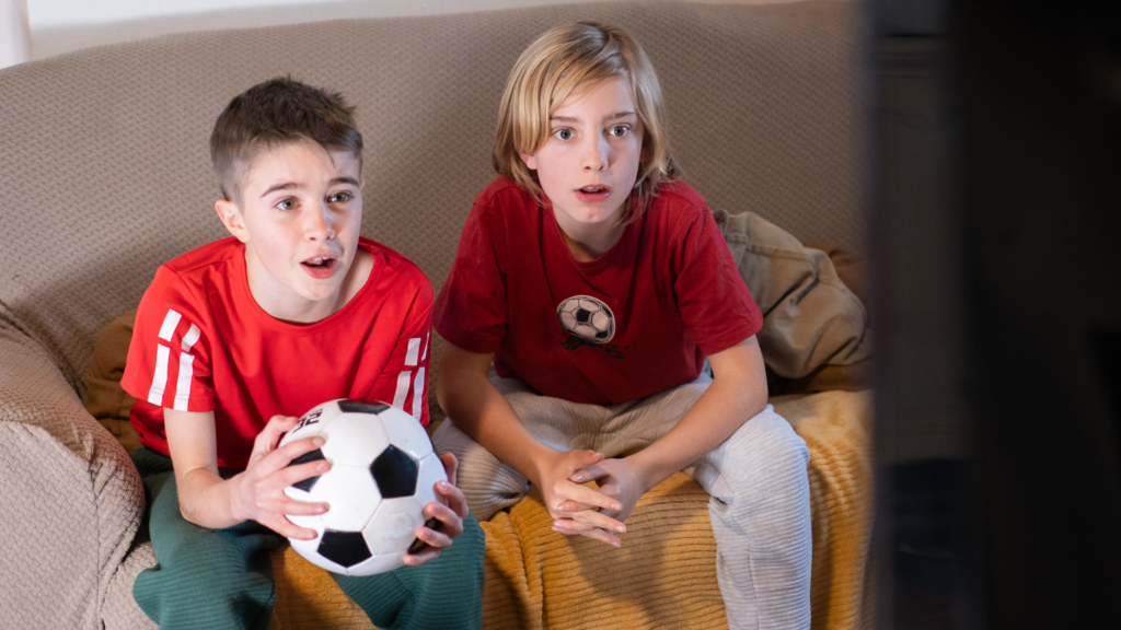 Kids sitting on couch with soccer ball