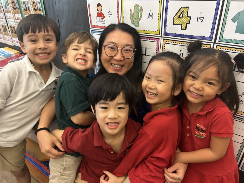 A preschool teacher surrounded by a group of students