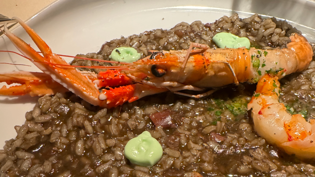 A BCN staple: Bomba rice cooked in cuttlefish's black ink, grilled branzino, langoustine, and octopus