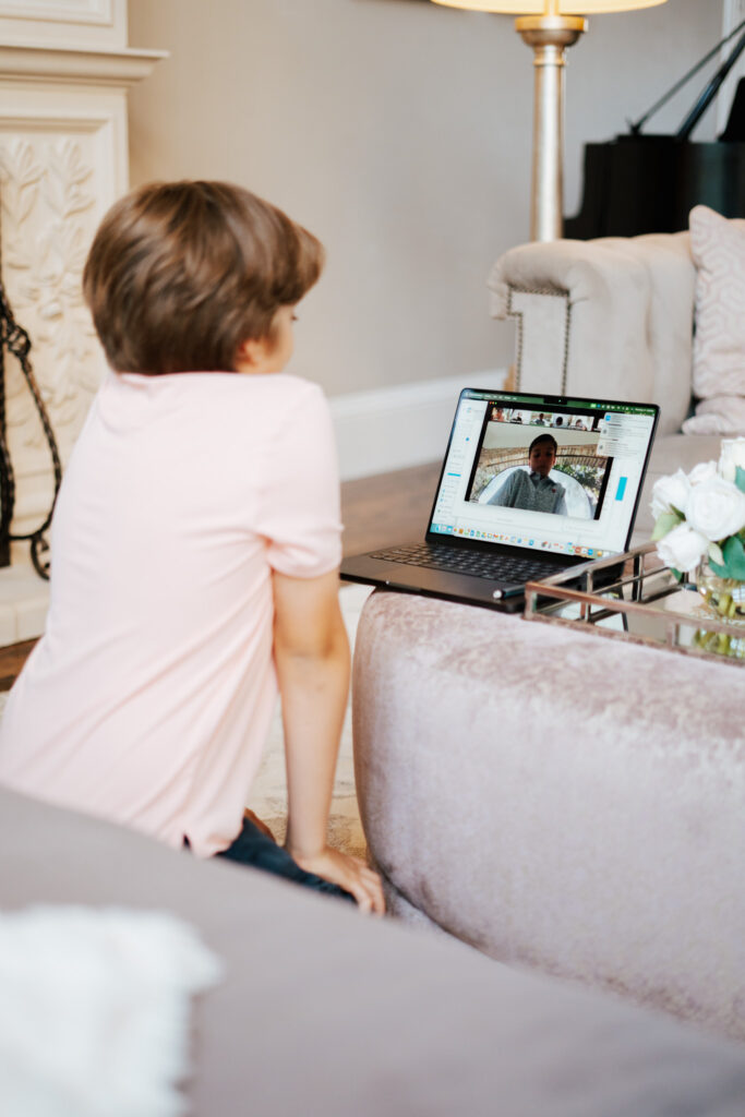A little boy watches a lesson on a laptop.