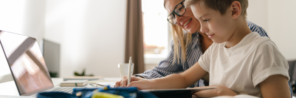 Stock image of mom and son working on homework at desk
