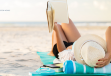 The Best of 2026 Summer Beach Reads woman lying on towel on beach reading a book
