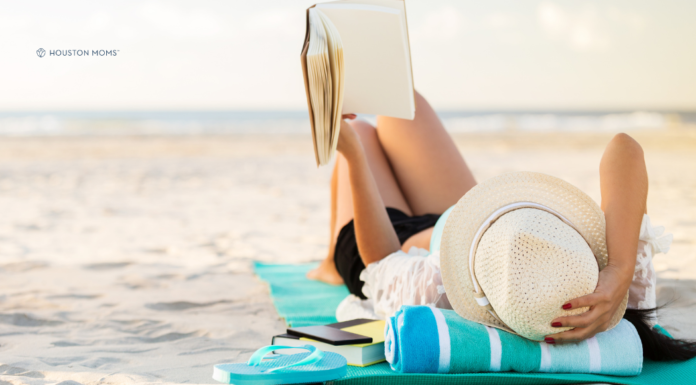 The Best of 2026 Summer Beach Reads woman lying on towel on beach reading a book